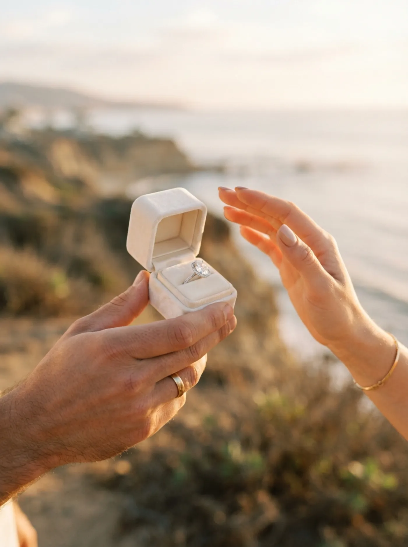 A ring box opened at golden hour on the California coast